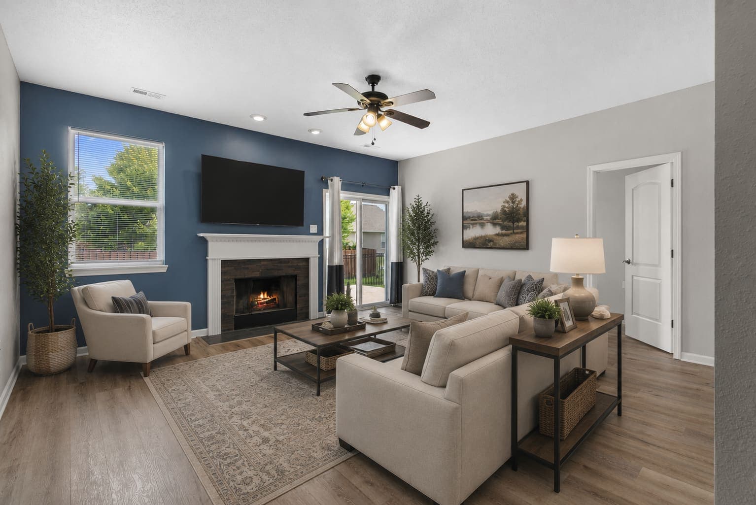 Virtually staged living room with fireplace, sectional, and blue accent wall